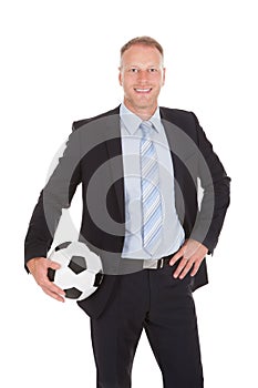 Smiling businessman holding soccer ball