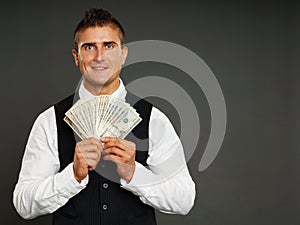 Smiling businessman holds money