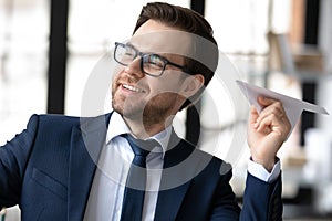 Smiling businessman laugh paper plane in office