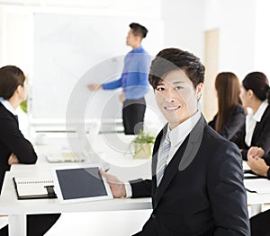 Smiling businessman looking at camera with colleague