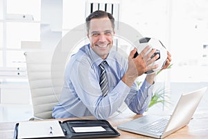 Smiling businessman looking at camera with foot ball