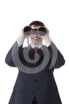 Smiling businessman looks through binoculars