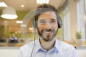 Smiling Businessman in the office on video conference, headset,