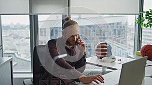 Smiling businessman phone conversation at office closeup. Man watching laptop