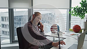 Smiling businessman phone conversation at office closeup. Man watching laptop