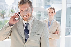 Smiling businessman on the phone looking at the camera