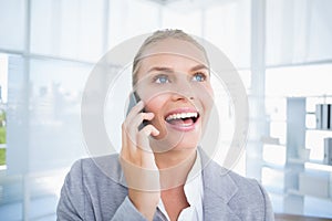 Smiling businessman phoning at her desk