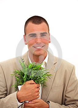 Smiling businessman with a plant