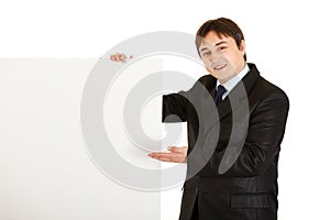 Smiling businessman pointing at blank billboard