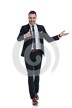 Smiling businessman pointing and presenting while walking