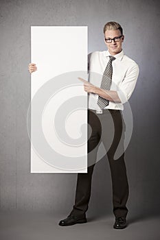 Smiling businessman presenting white blank billboard.