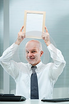 Smiling businessman raises, empty, copyspace-ready sign photo