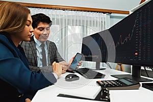 Smiling businessman showing stock market data on phone to woman. Infobahn.