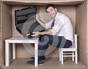 Smiling businessman shows empty briefcase, laughs at his own naivety
