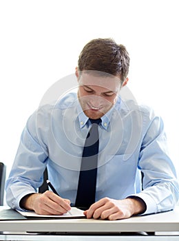 Smiling businessman signing papers in office