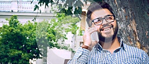 Businessman sitting on park bench with coffee using mobile phone.