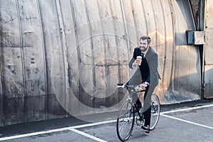 smiling businessman in suit with coffee to go in hand