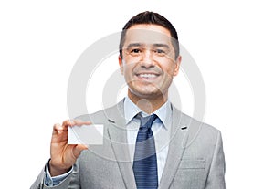 Smiling businessman in suit showing visiting card