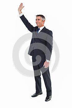 Smiling businessman in suit waving