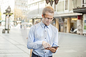 Smiling Businessman with tablet on street