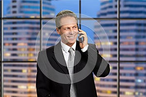 Smiling businessman talking on smartphone.