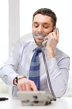 Smiling businessman with telephone dialing number