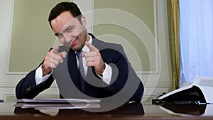 Smiling businessman with thumb up and showing okey