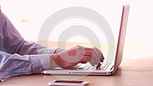 Smiling businessman typing on his laptop