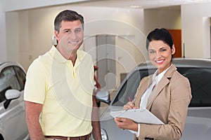 Smiling businessman undersign a car contract