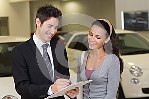 Smiling businessman undersign a car contract