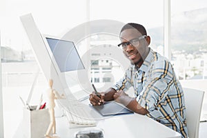 Smiling businessman using digitizer at desk