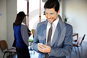 Smiling businessman using smartphone