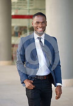 Smiling businessman walking in the city