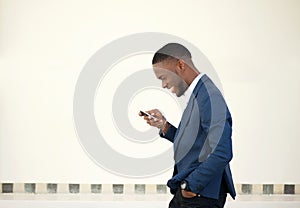 Smiling businessman walking and sending text message