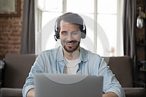 Smiling businessman wear headset use laptop having communication through videoconference photo