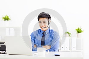 Smiling businessman wearing a headset at the office