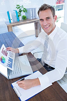 Smiling businessman working with flow charts