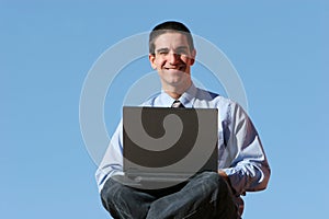 Smiling businessman working on laptop