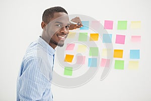 Smiling businessman writing on sticky notes