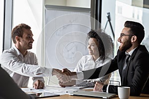 Smiling businessmen handshake closing deal at meeting