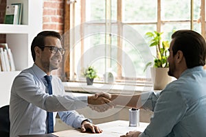 Smiling businessmen handshake closing deal at meeting