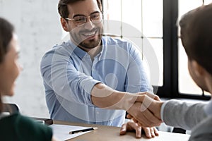 Smiling businessmen handshake closing deal at office meeting