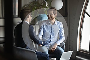 Smiling businessmen handshake get acquainted at briefing