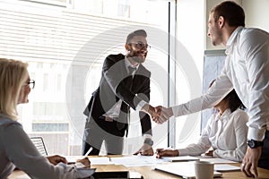 Smiling businessmen handshake greeting at team office meeting