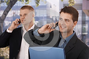 Smiling businessmen making phone call