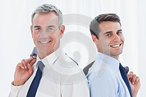 Smiling businessmen posing back to back together while holding t