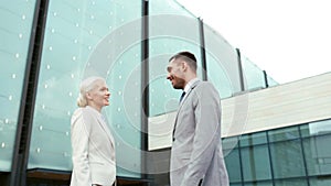 Smiling businessmen shaking hands on street