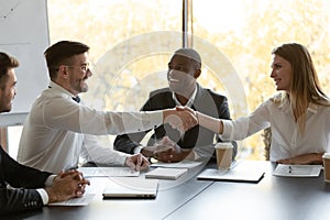 Smiling businesspeople handshake closing successful deal at meeting