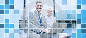 Smiling businesspeople with laptop outdoors