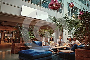 Smiling businesspeople relaxing in the lounge area of an office photo